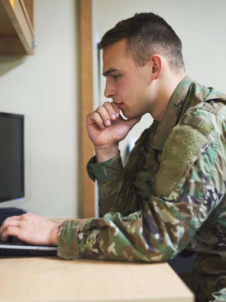 Military Member Using Laptop In Office