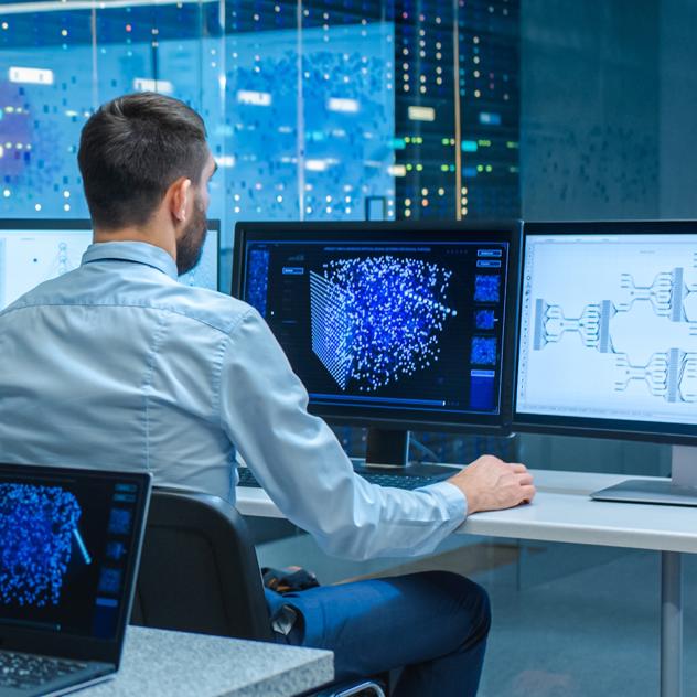 JJ Photo Man Sitting At Desk Working On Multiple Displays Shutterstock 1538502419
