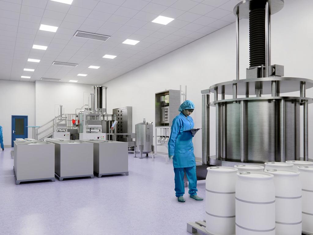 Worker in blue protective gear in a facility looking at columns on a pallet