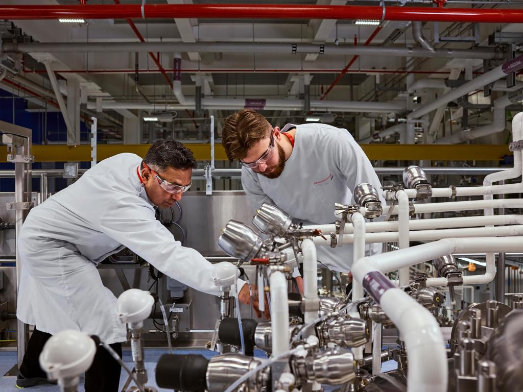 Two people work together in high tech manufacturing.