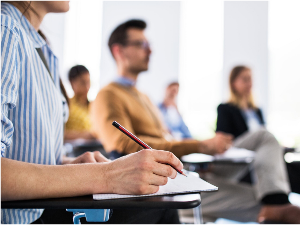 A group of people sitting and taking notes