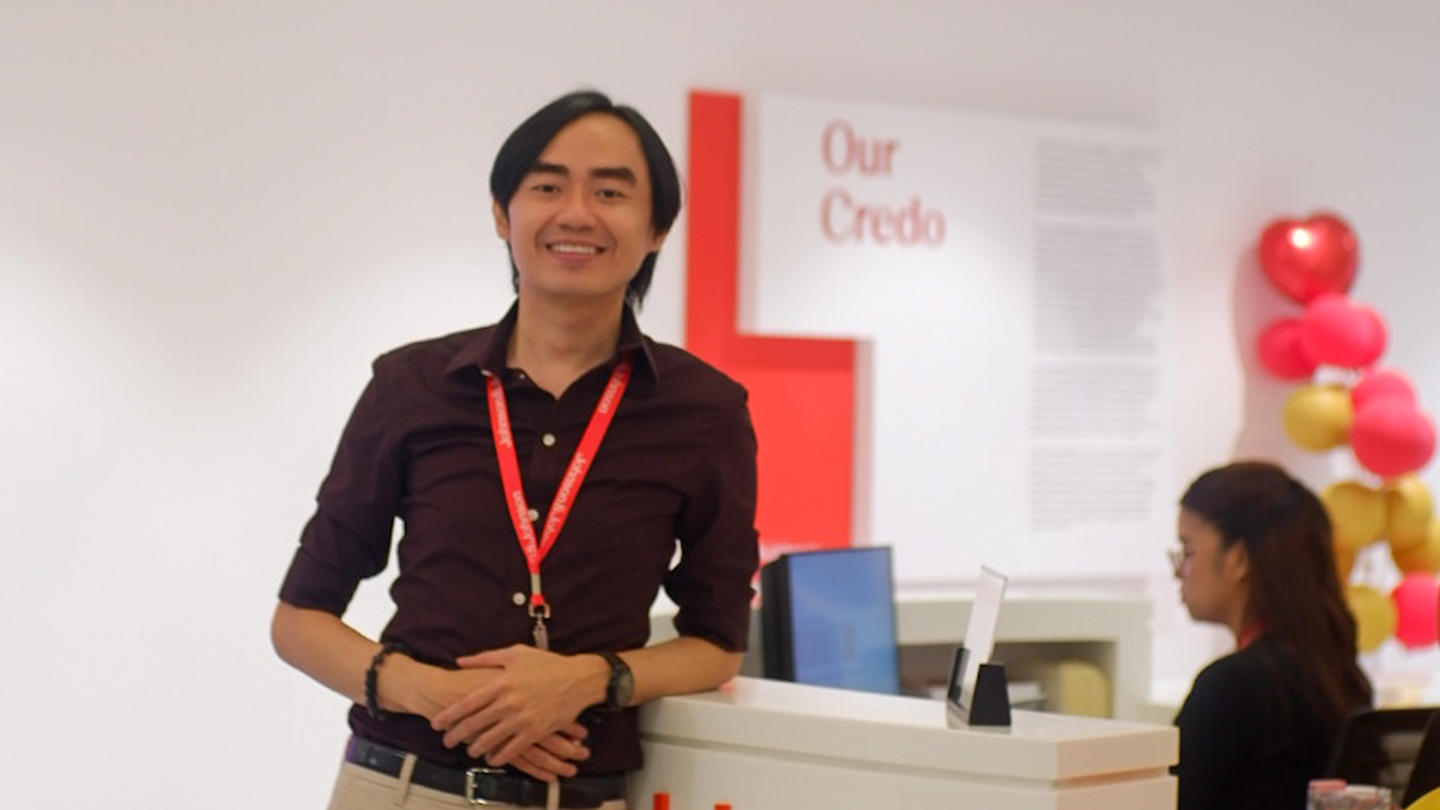 A man stands in front of the lobby desk at J&J Manila