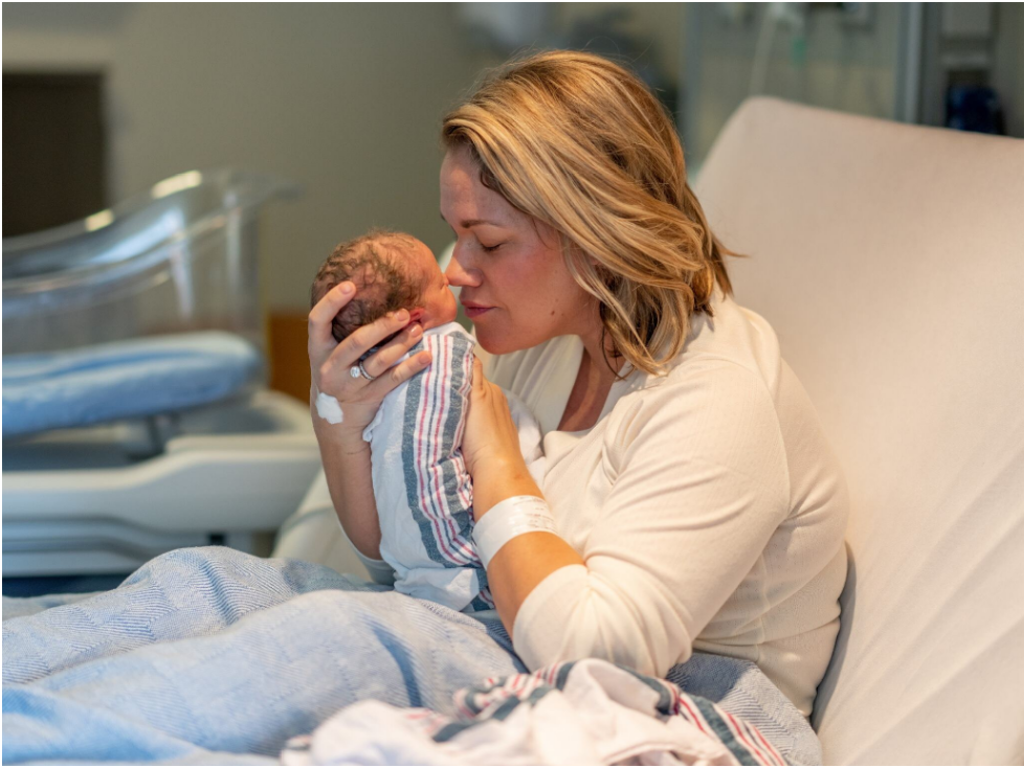 A mother in a hospital bed holding her newborn